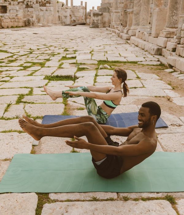 Group of diverse people sitting on yoga mats smiling.